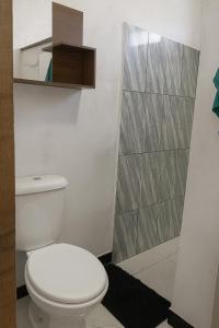 a bathroom with a white toilet and a shower at Residencial céu aberto in Porto Seguro