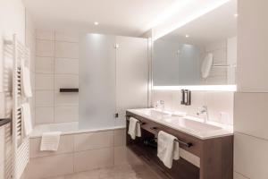 een witte badkamer met een wastafel en een bad bij Home4You in Sölden +23 foto's