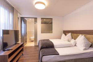 een slaapkamer met een bed en een flatscreen-tv bij Home4You in Sölden