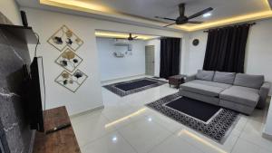 a living room with a couch and a tv at SSHomestay in Skudai