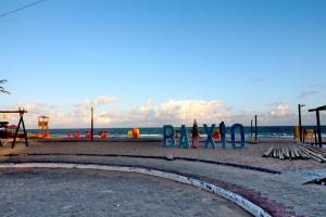 um parque infantil na praia com o oceano ao fundo em Casa com Piscina e Churrasqueira em Baixio em Baixio