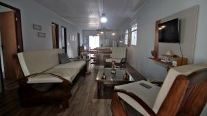 uma sala de estar com um sofá, cadeiras e uma TV em Casa com Piscina e Churrasqueira em Baixio em Baixio