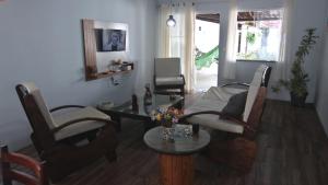 uma sala de estar com uma mesa, cadeiras e um sofá em Casa com Piscina e Churrasqueira em Baixio em Baixio