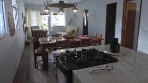 uma cozinha e sala de jantar com uma placa de fogão e forno em Casa com Piscina e Churrasqueira em Baixio em Baixio mais 24 fotografias