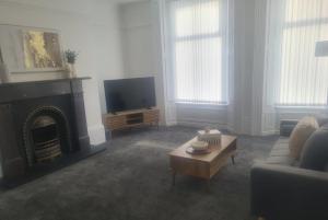 a living room with a fireplace and a tv at Modern one bed close to city in Sunderland