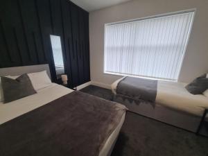a hotel room with two beds and a window at Modern one bed close to city in Sunderland