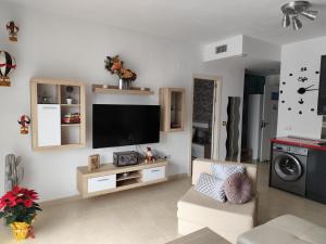 a living room with a flat screen tv on a wall at ÁTICO RILQUE, Apartamentos Independientes con Jacuzzi Privado y Terraza en Ronda in Ronda