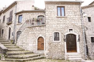 an old stone building with stairs and two doors at Gesualdo Suites in Gesualdo
