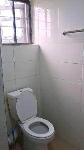 a bathroom with a white toilet and a window at J-D Suites in Ozuoba