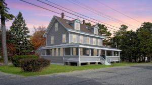 une grande maison avec une terrasse couverte dans une rue dans l'établissement A Shore Thing, à Surfside