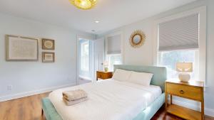 une chambre blanche avec un lit et deux fenêtres dans l'établissement A Shore Thing, à Surfside