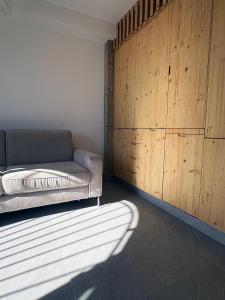 ein Wohnzimmer mit einem Sofa und einer Holzwand in der Unterkunft Vivienda El Tiburón 02 in Almerimar