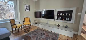 a living room with two chairs and a flat screen tv at La Quiete del Mattino in Torre Pellice