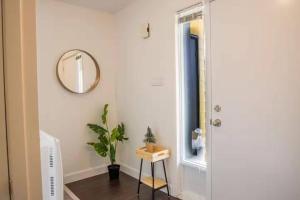 a hallway with a mirror and a plant at Nature & Breathtaking View - Le Dumont - B in Saint-Philémon