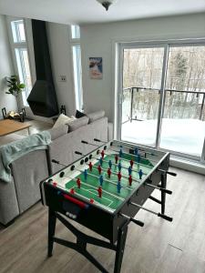a living room with a foos ball on a table at Nature & Breathtaking View - Le Dumont - B in Saint-Philémon +22 photos