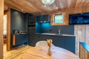 eine Küche mit blauen Wänden und einem Holztisch in der Unterkunft La Duche 101 in Le Grand-Bornand + 19 Fotos