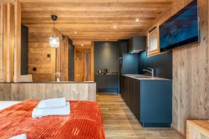 ein Schlafzimmer mit einem großen Bett und eine Küche in der Unterkunft La Duche 101 in Le Grand-Bornand