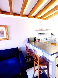 a kitchen with a bar with chairs and a couch at L'Andalouse in Vailly-sur-Sauldre