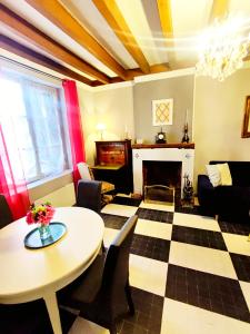 a living room with a table and a fireplace at L'Andalouse in Vailly-sur-Sauldre