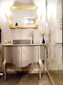 a bathroom with a sink and a mirror at L'Andalouse in Vailly-sur-Sauldre +18 photos