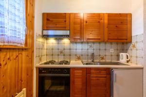 a kitchen with a stove and a sink and a microwave at Résidence Dent d'Hérens 18B - au calme à Evolène in Evolène