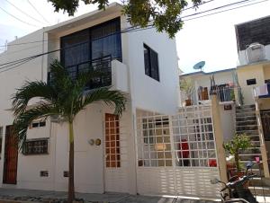 a house with a palm tree in front of it at Casa Herrera in Santa Cruz Huatulco
