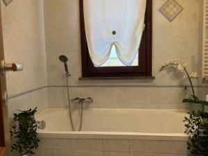 een badkamer met een bad en een raam bij Green Luxury House in Casal Palocco