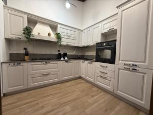 een grote witte keuken met witte kasten en een magnetron bij Green Luxury House in Casal Palocco