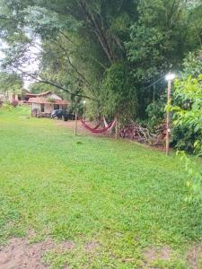 a yard with a hammock in the grass at camping elementais in São Thomé das Letras