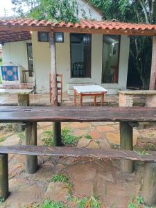 a picnic table in front of a house at camping elementais in São Thomé das Letras