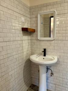 a white bathroom with a sink and a mirror at Patamu Restaurants Lodge & Safaris in Karatu +31 photos
