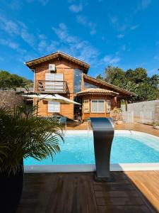 Chalé Vale da Mata - São Roque SP في ساو روكي: منزل به حوض سباحة أمام المنزل
