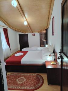 a bedroom with a large bed and a table at Vila Bratocea in Cheia +86 photos