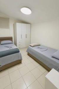 BR's New Bazaar Villa في تيرانا: غرفة نوم بسريرين وبيض