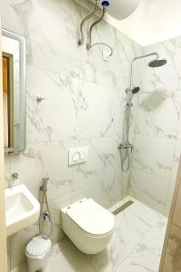 BR's New Bazaar Villa في تيرانا: حمام ابيض مع مرحاض ودش