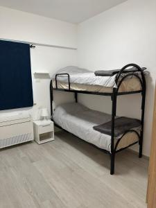 a room with two bunk beds and a flat screen tv at Appartamenti Cataleya in Cuccurano