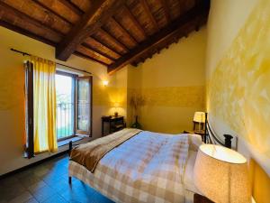 Agriturismo Le Ceregne Bio في La Torre: غرفة نوم بها سرير ونافذة كبيرة +95 صورة