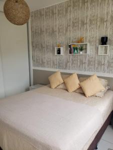 a bed with white sheets and pillows in a room at Apartamento no centro do Rio Vermelho-Ondina in Salvador