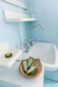 a bathroom with a sink and a basket of toothbrushes at Vagia Traditional, Aegina Island in Vaia +171 photos