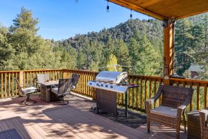 a patio with a grill and chairs on a deck at PMC Mountainside Cabin Hit the Trails, Play Pool! in Pine Mountain Club