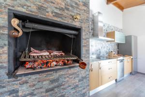 a kitchen with a fireplace with meat on it at La Villarina in Sitrama de Tera