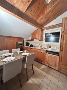 Ferienwohnung mit Herz في شويز: مطبخ مع خزائن خشبية وطاولة وكراسي