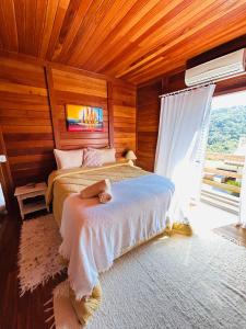 Chalé Vale da Mata - São Roque SP في ساو روكي: غرفة نوم بها سرير في غرفة بجدران خشبية