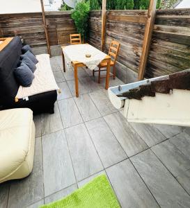 eine Terrasse mit einem Sofa und einem Tisch und Stühlen in der Unterkunft Appartement avec terrasse in Drancy