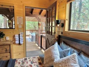 ein winziges Haus mit einer Tür, die zu einer Veranda führt in der Unterkunft Western theme! Amazing Spa, Fireplace and Deck! in Overgaard