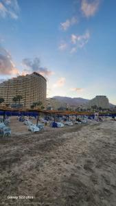 a beach with a bunch of chairs and buildings at Pyramids Porto Sokhna Hotel Apartments in Ain Sokhna