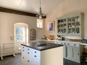 a kitchen with white cabinets and a black counter top at Château Meilhen in Les Mages