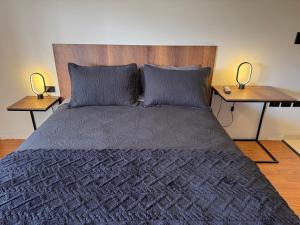 ein Schlafzimmer mit einem Bett mit zwei Nachttischen in der Unterkunft Black Chic Studio in Cochabamba + 13 Fotos