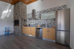 a kitchen with a stainless steel refrigerator and wooden cabinets at La Villarina in Sitrama de Tera