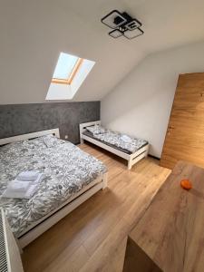 a bedroom with two beds and a window at Szekely Apartman in Ciumani
